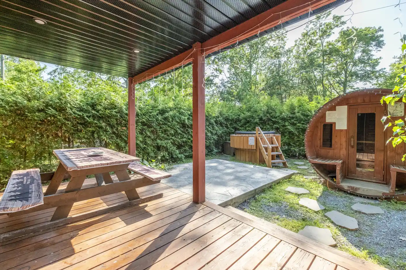 Covered porch with outdoor seating and private sauna view