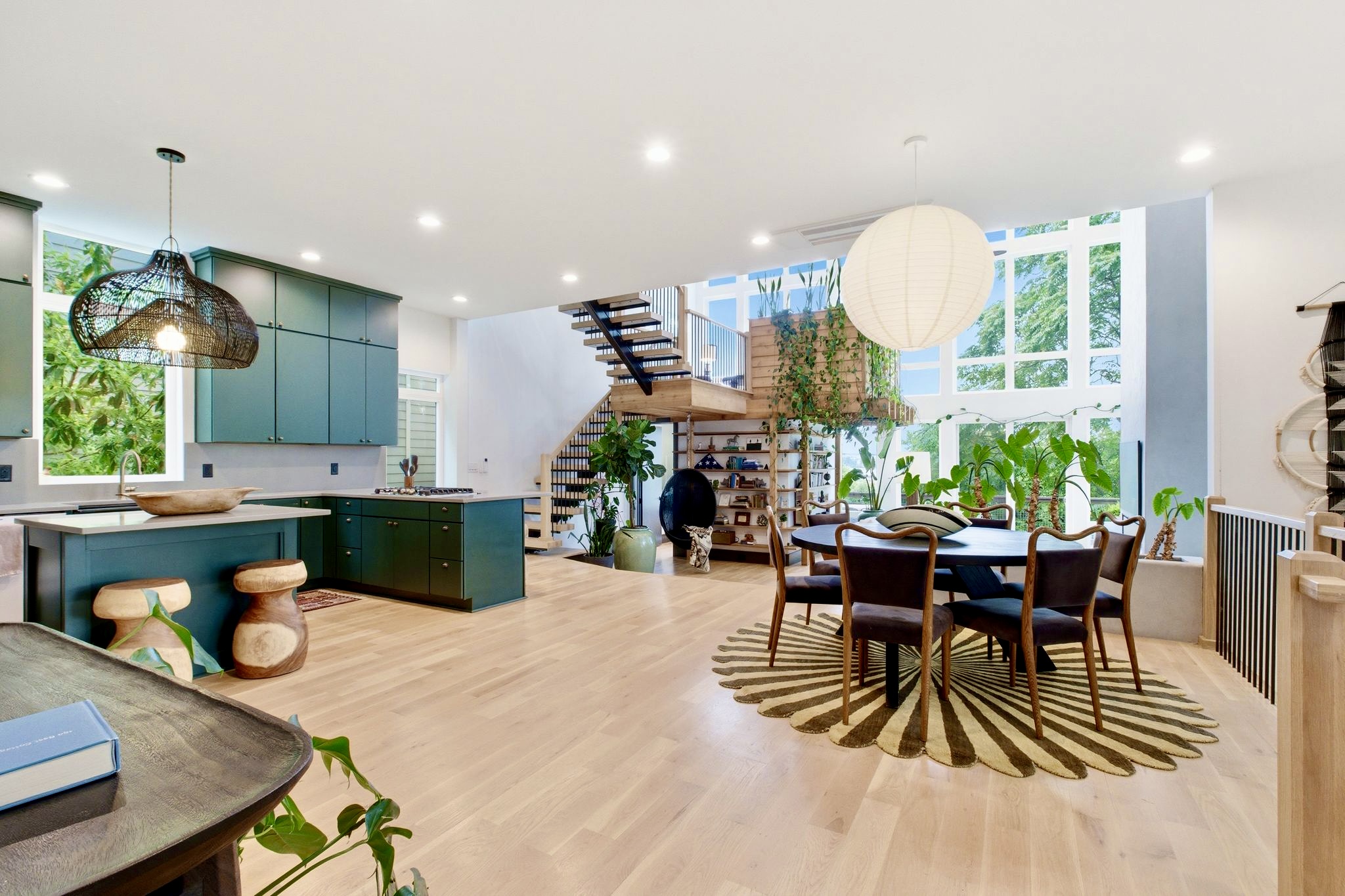 Sun-filled open-plan dining & kitchen w/ sleek teal cabinetry & room for the whole group.

