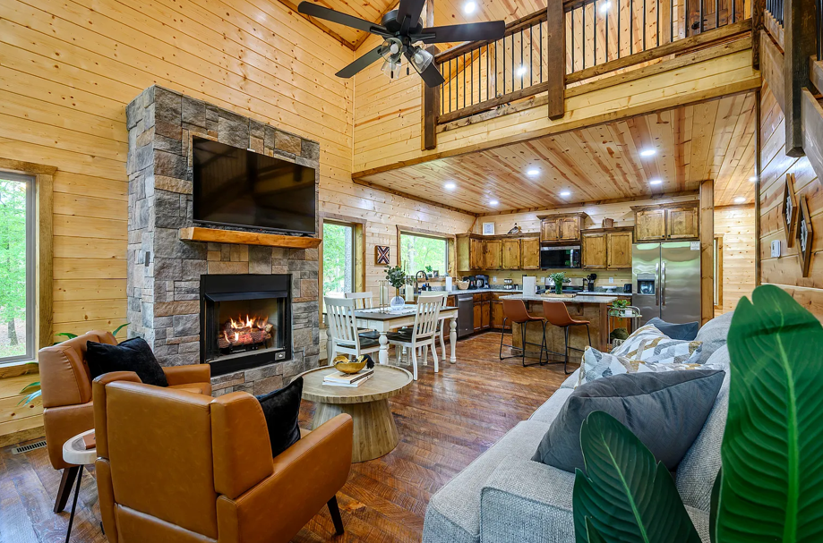 Spacious open-concept living area with soaring ceilings and stone fireplace