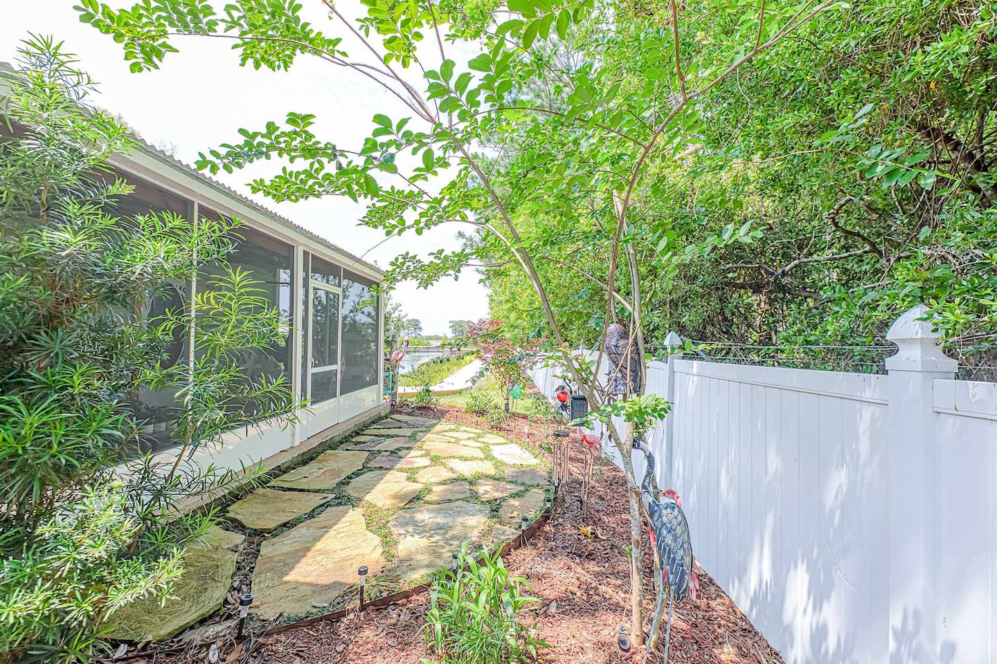 Outdoor Serenity: Explore the lush garden path leading to tranquil waterside views!