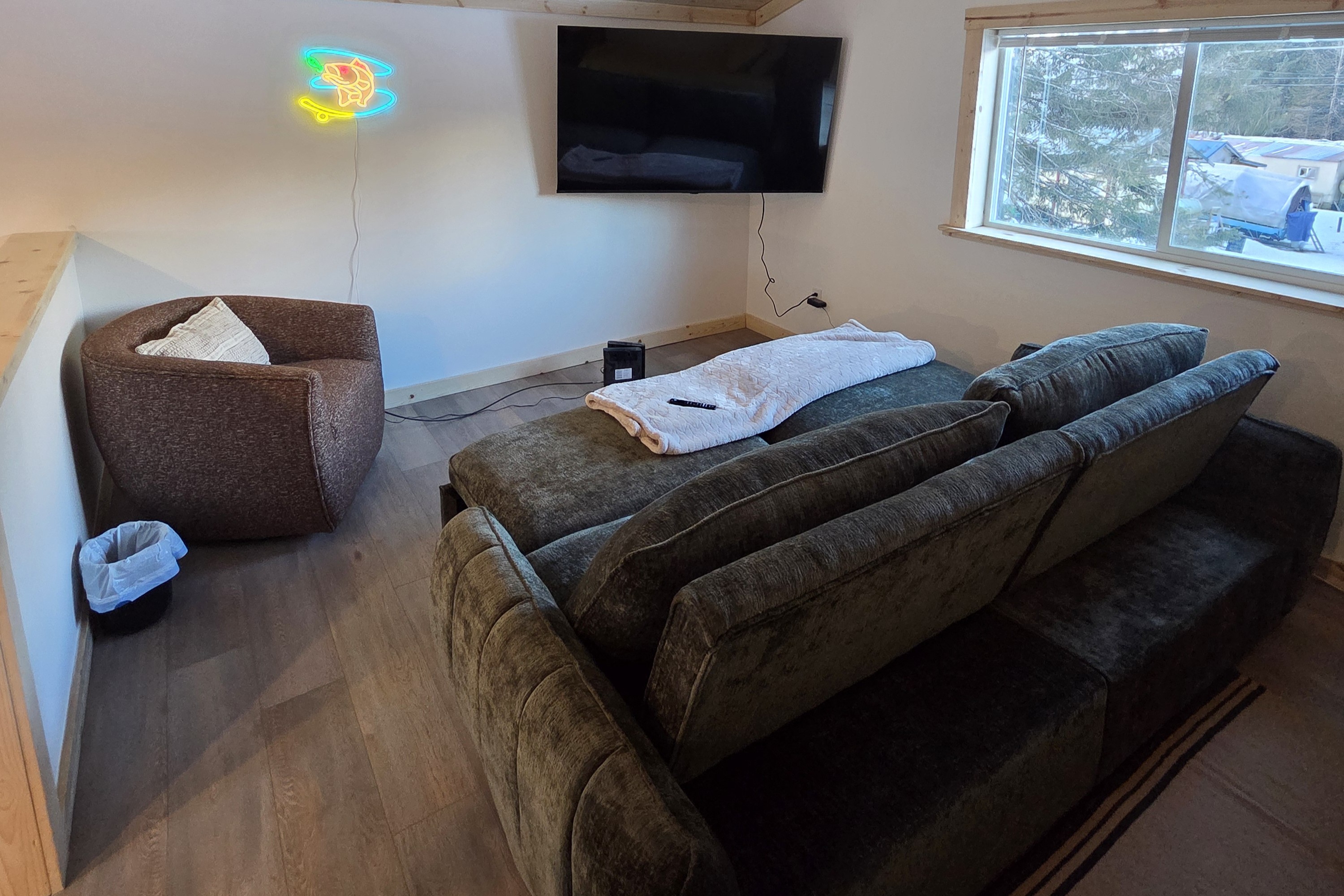Loft living area includes large swivel chair, sofa sleeper, and big screen TV.