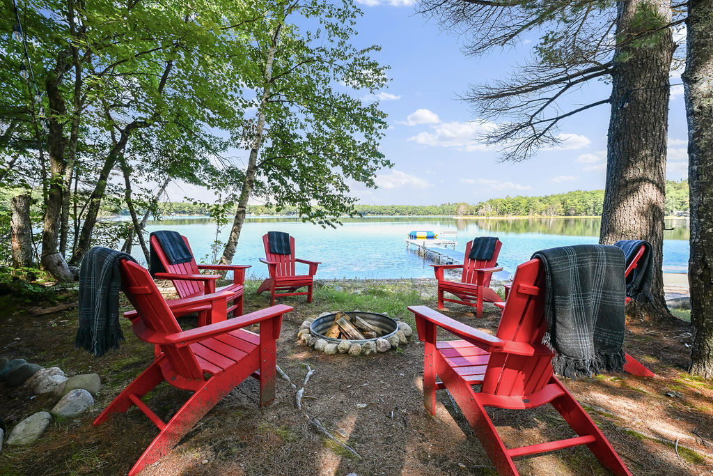 Lakeside fire pit with sunset views and overhead string lights