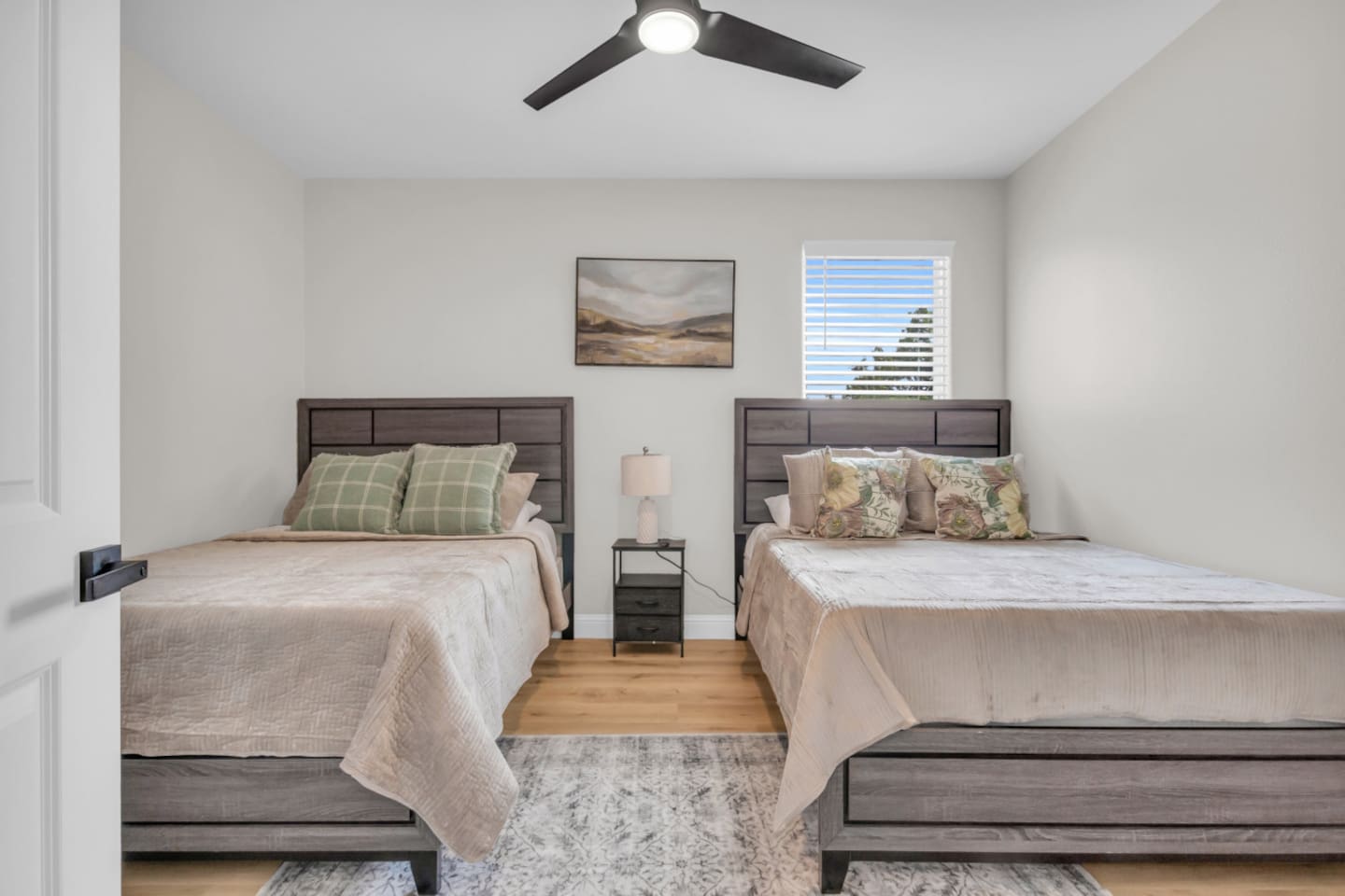 Guest bedroom with queen beds and ceiling fan comfort.