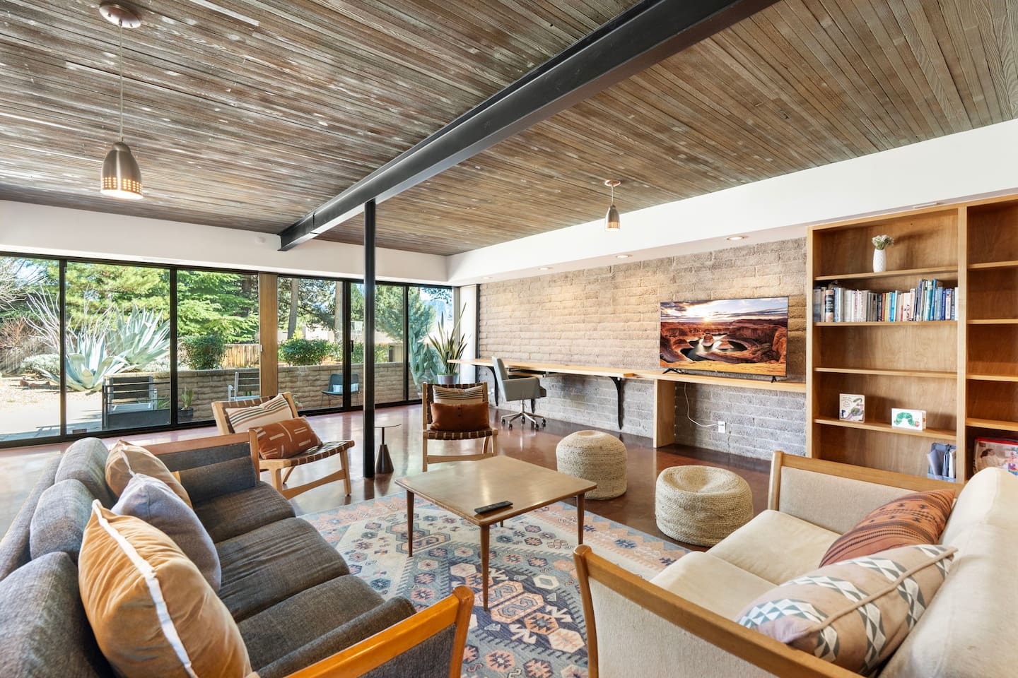 Spacious open living area with warm wood ceilings and inviting mid-century charm.