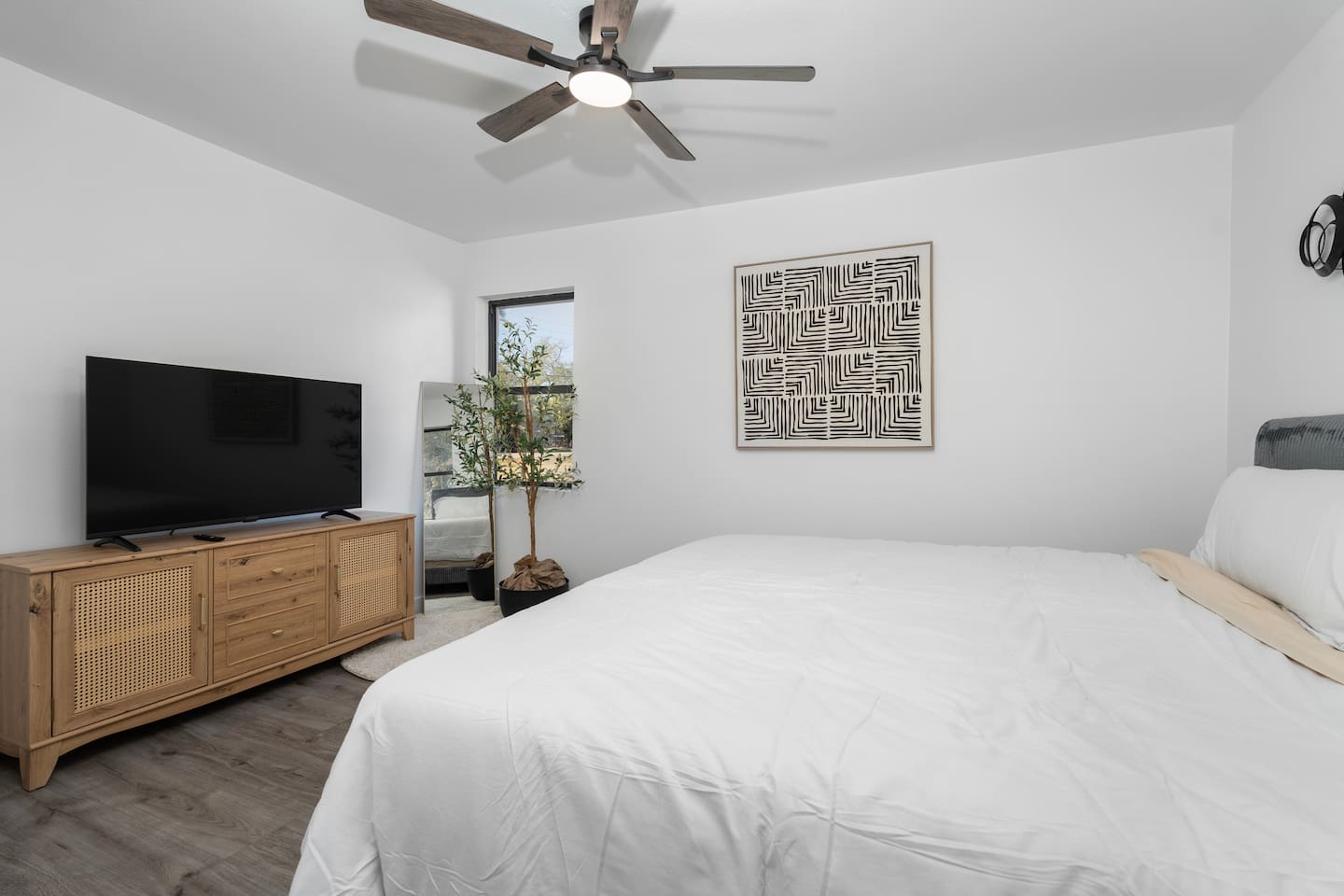 A calm and comfortable room featuring a King bed, TV with streaming channels, a ceiling fan, and crisp bed linens. Ideal for quiet nights in and a great night’s sleep.
