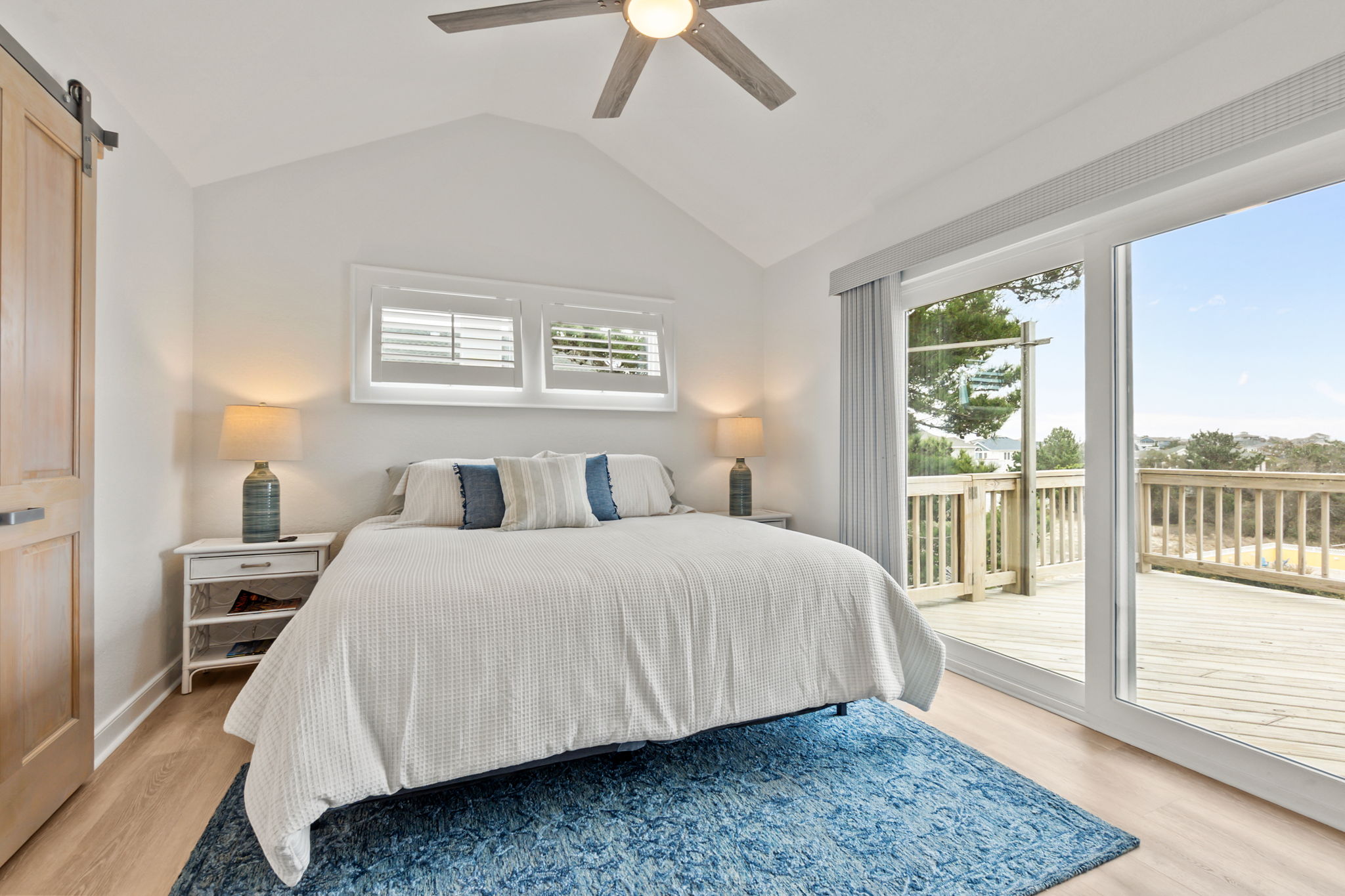 King Bedroom #1 – Bright bedroom with a king bed and direct access to the deck through sliding doors.