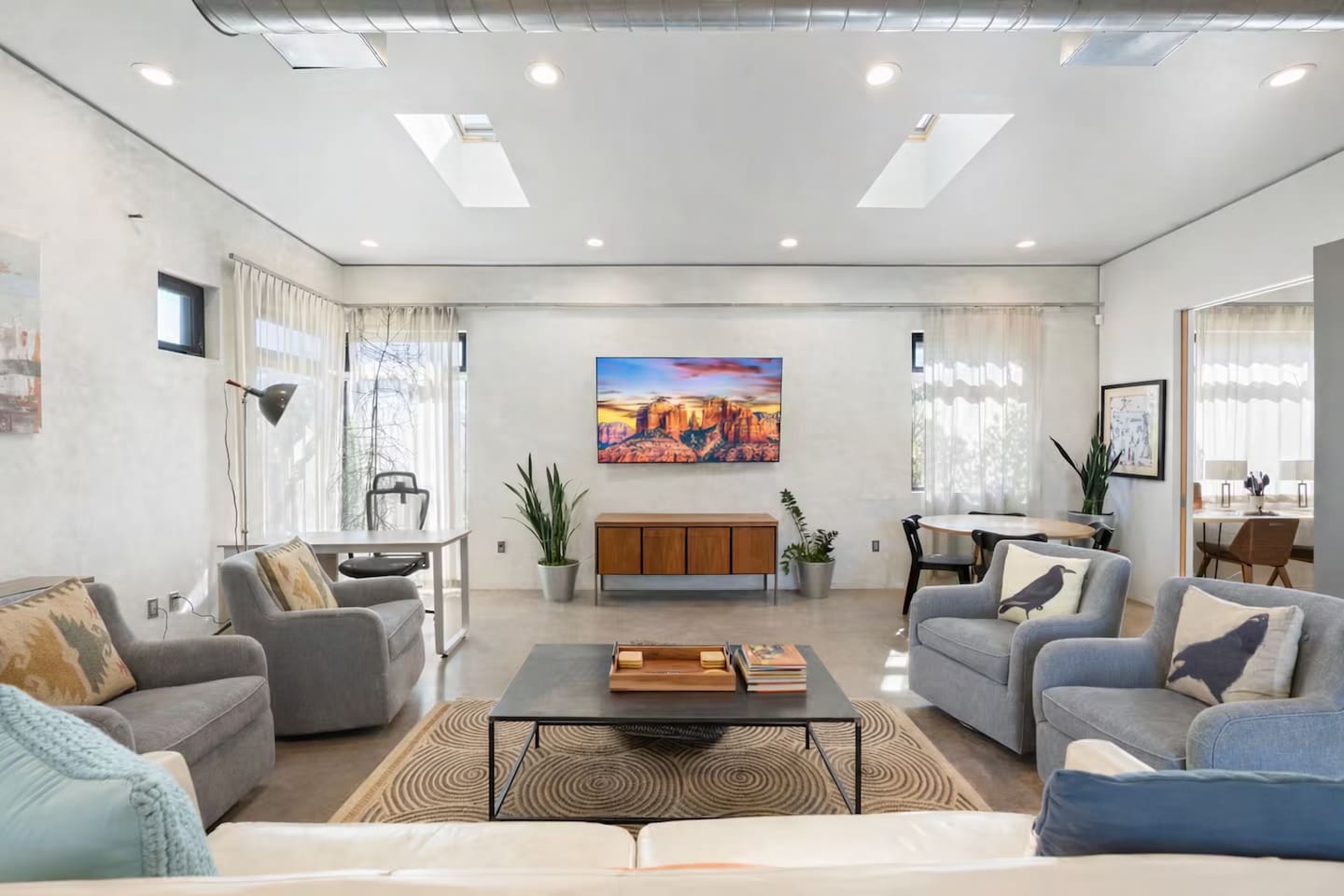 Bright, modern living room with comfortable seating, clean design, and vibrant artwork — a perfect space to relax and unwind.