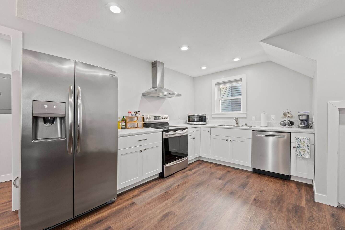 Fully equipped kitchen with a fridge, oven, stove, coffee maker, microwave, and all the essentials for a home-cooked meal.