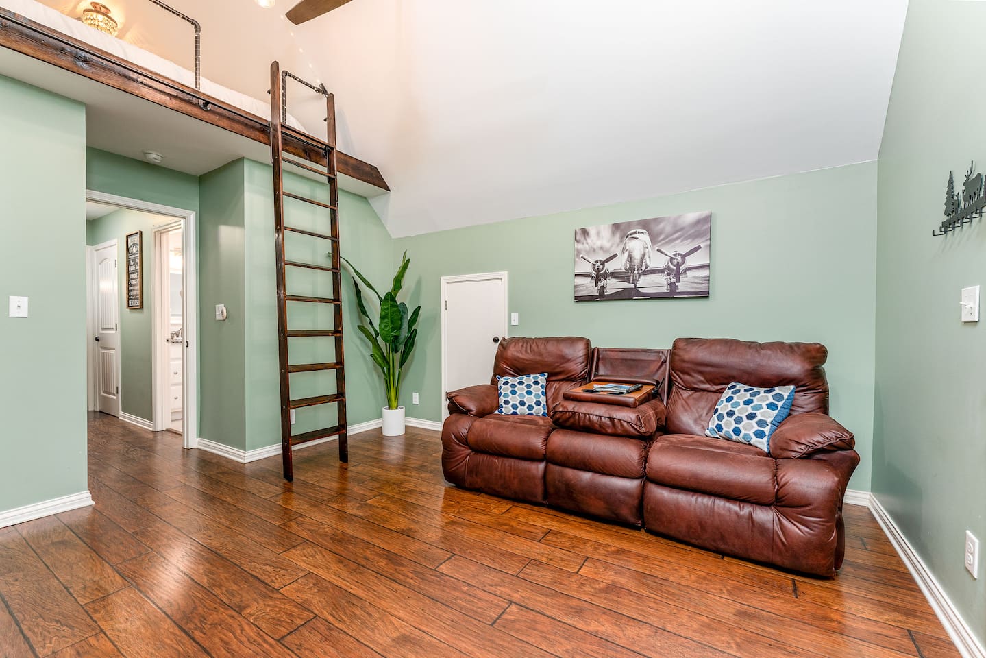 Living room with Library ladder for access to cozy loft