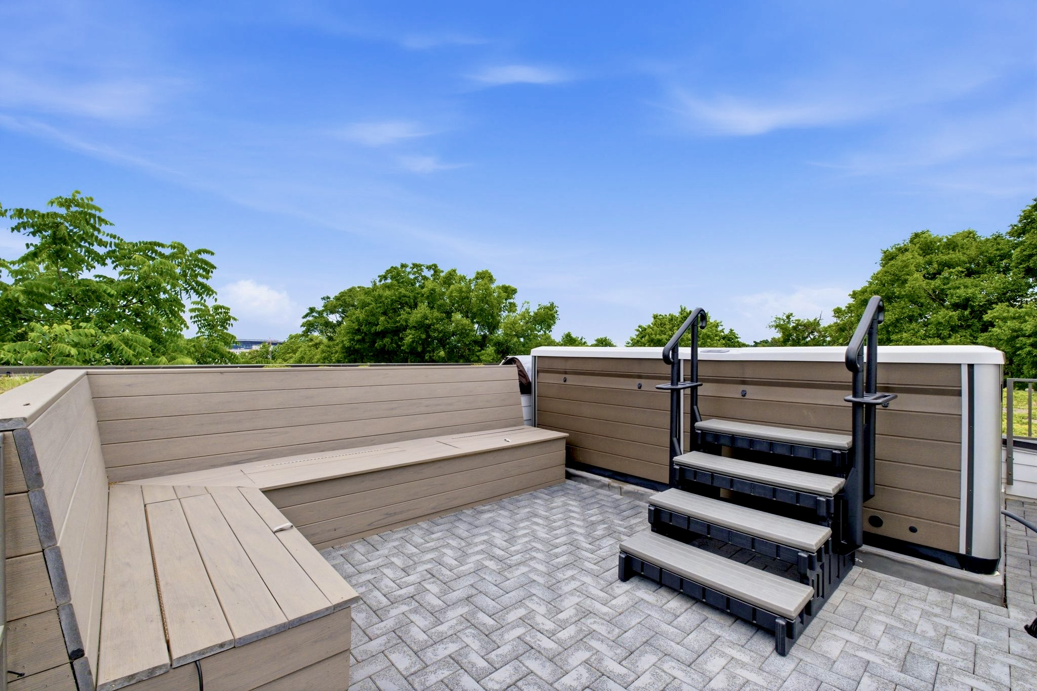 Expansive rooftop deck w/ herringbone tile & open sky — a blank canvas for sunny afternoons.
