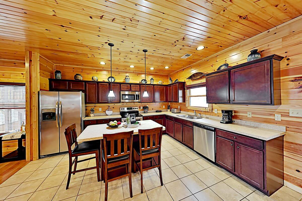 Fully equipped kitchen with island seating for three (no food/drinks provided).