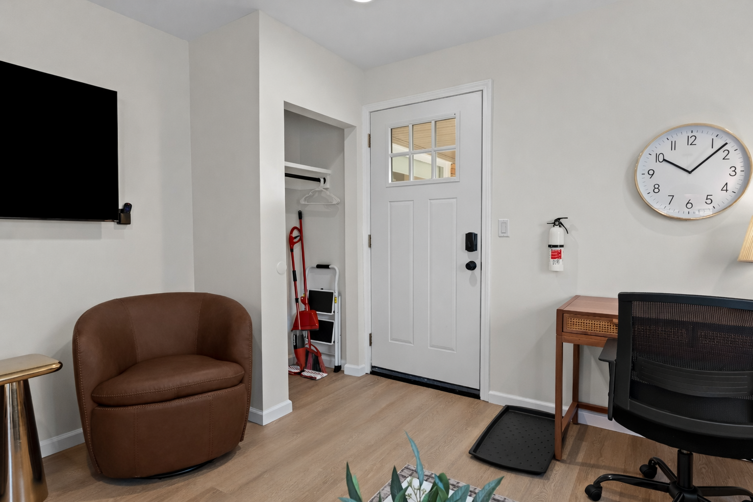 Functional entry and living space with cozy seating, smart TV, and dedicated workspace—welcoming, organized, and designed for comfortable everyday stays.