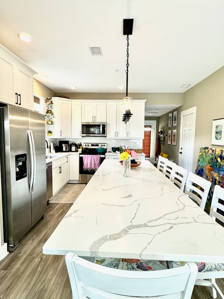 Extended counter - extra seating and work spaceCounter stools with cushionsGlass top electric range and microwaveFull size fridgeFull pantryKeurig and drip coffee makersInstant water heaterToasterBlender