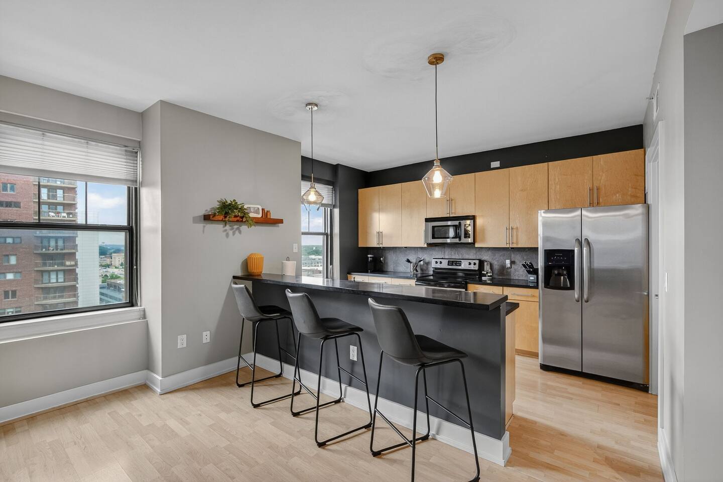 Sip morning coffee or evening cocktails at the modern breakfast bar with seating for three. Natural light pours in from city-view windows, while stylish pendant lighting sets the tone for your stay.