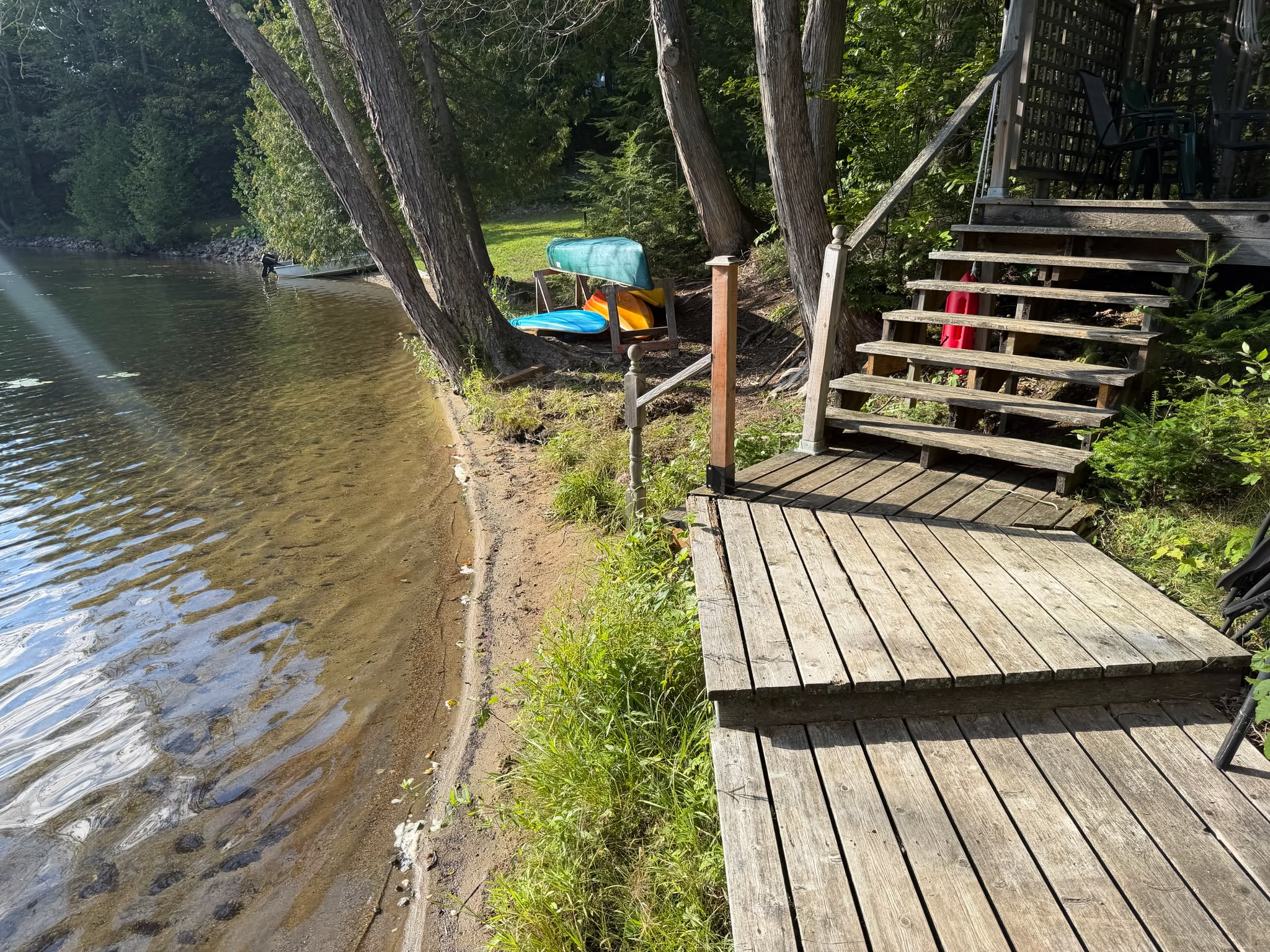 Walkway to dock and deck with sandy shore of lake