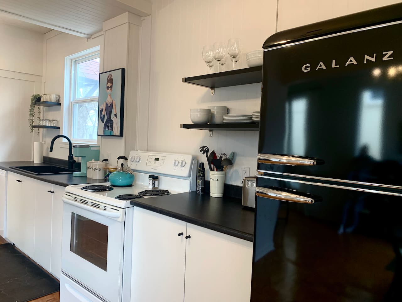 Fully equipped kitchen with stove, microwave, coffee maker, cookware, and dining essentials.