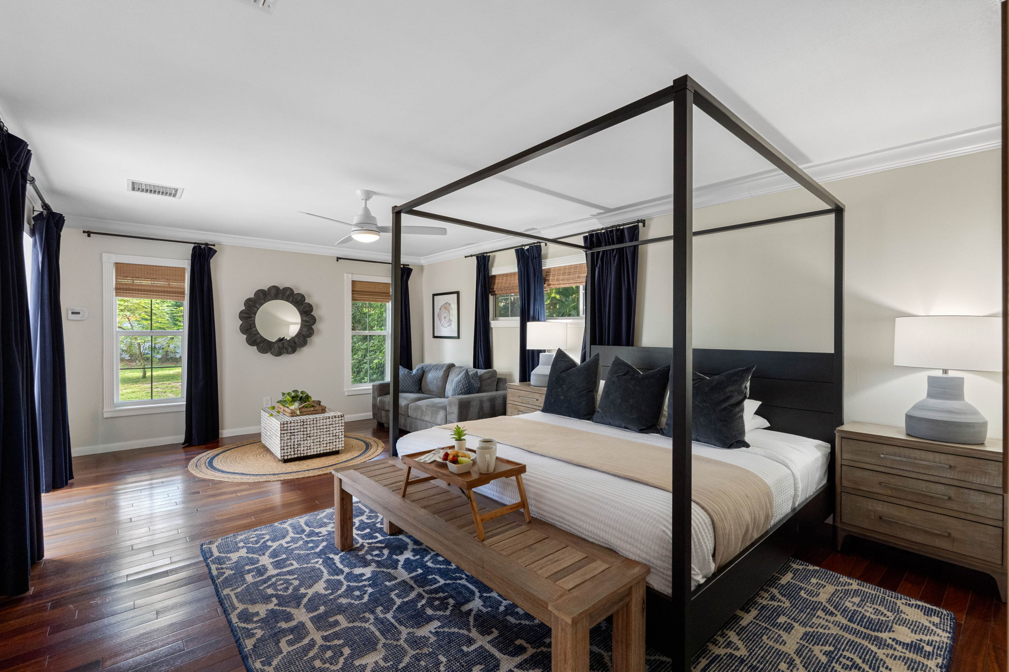 This bedroom exudes comfort and sophistication with a modern canopy bed and designer accents.