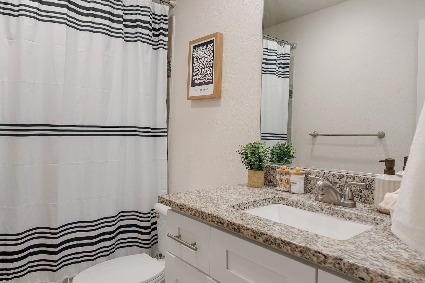 The bathroom is equipped with a stylish shower and a well-lit vanity. Practical amenities ensure a comfortable and convenient stay.