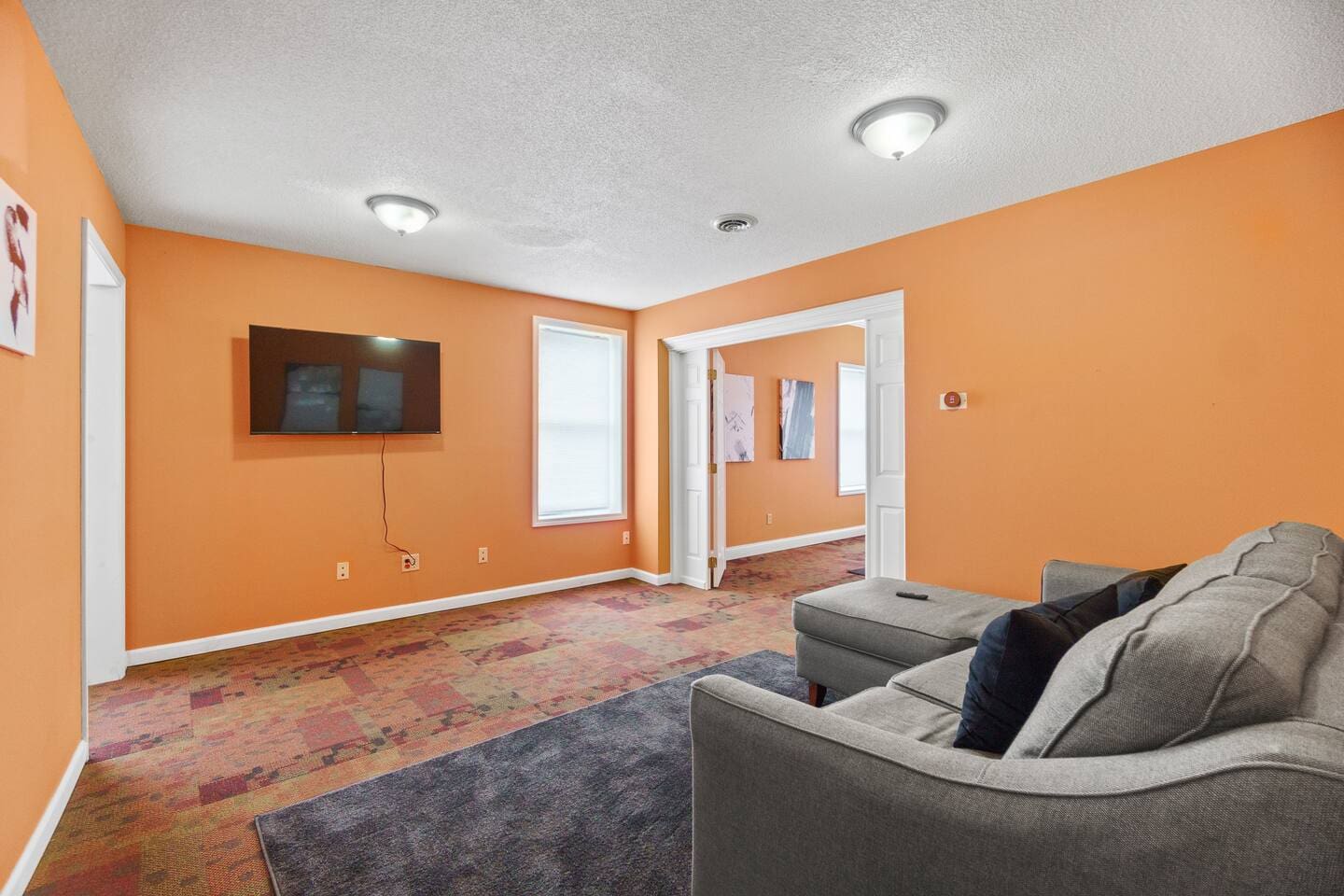 View from the couch in a spacious living area, complete with a flat-screen TV, creating a perfect spot to relax and unwind.