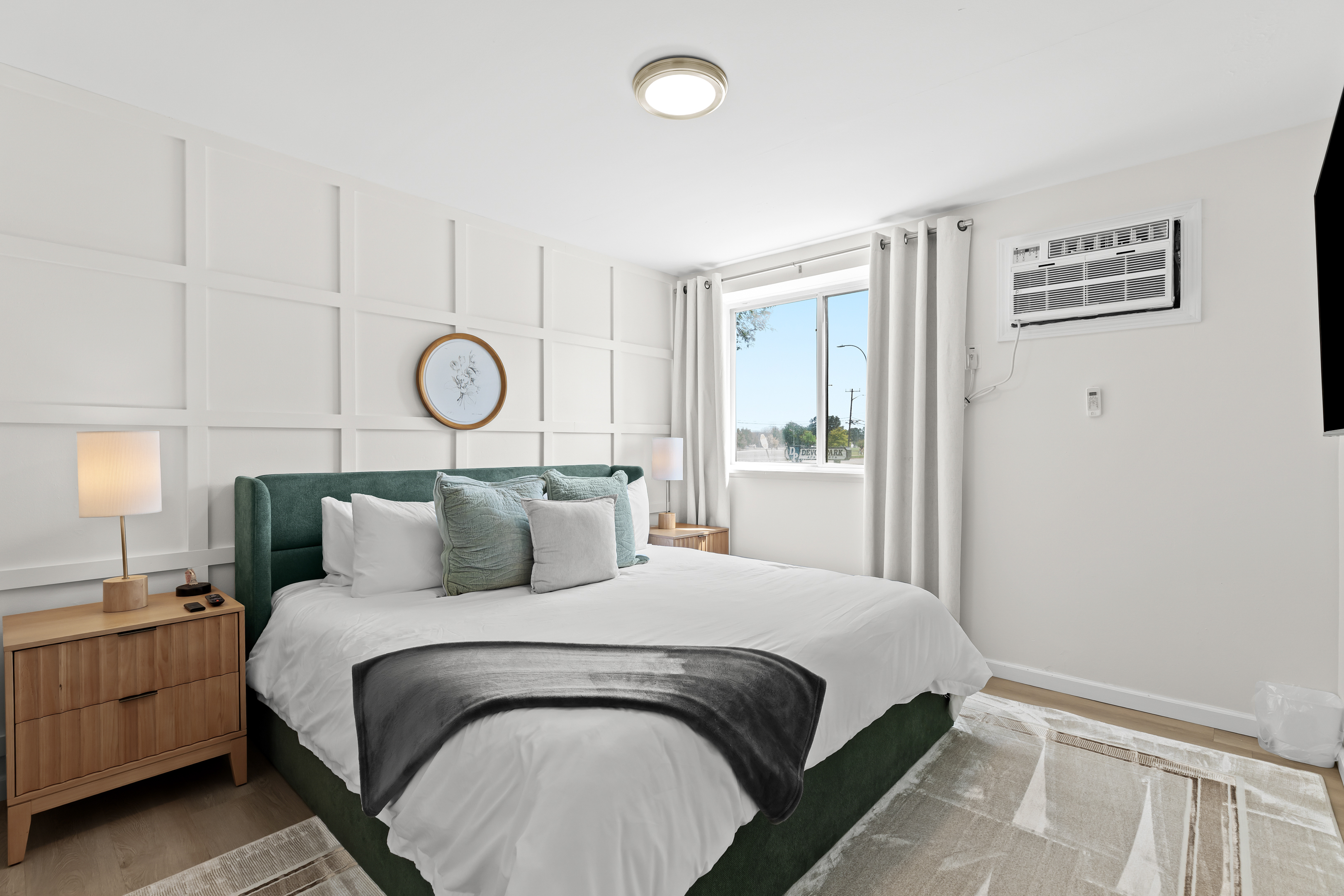 Wake up to natural light in this beautifully styled bedroom with plush pillows, mid-century nightstands, and modern comfort.