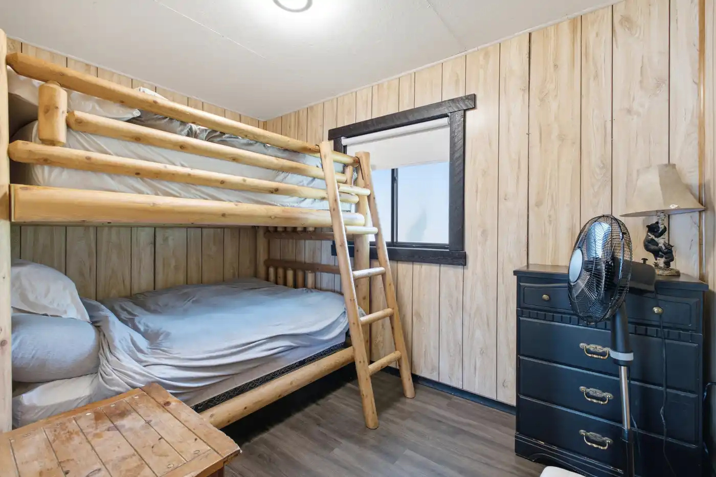 Bunk bedroom with dresser and natural light