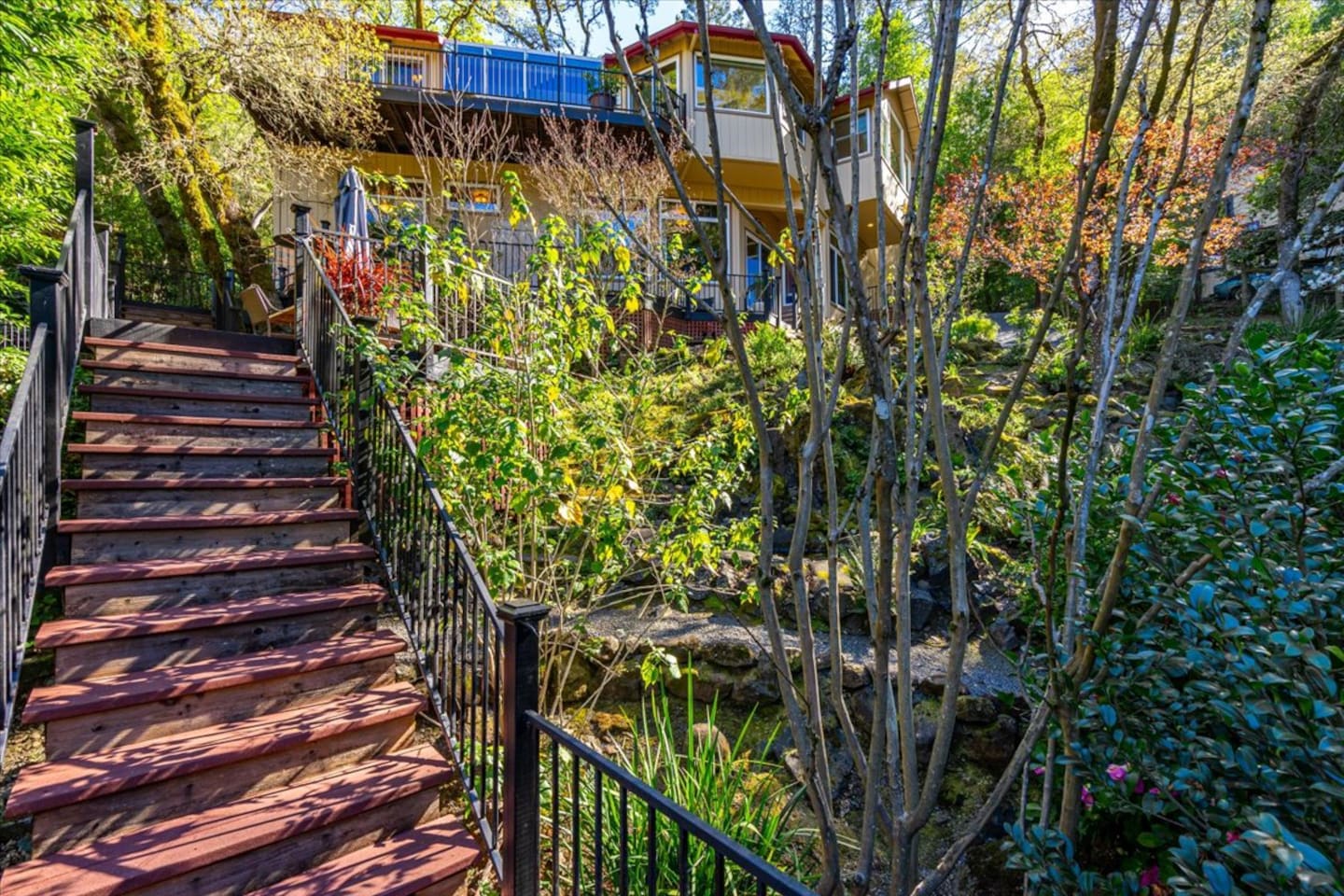 Descend the stairs from the house to enter a lush garden oasis.