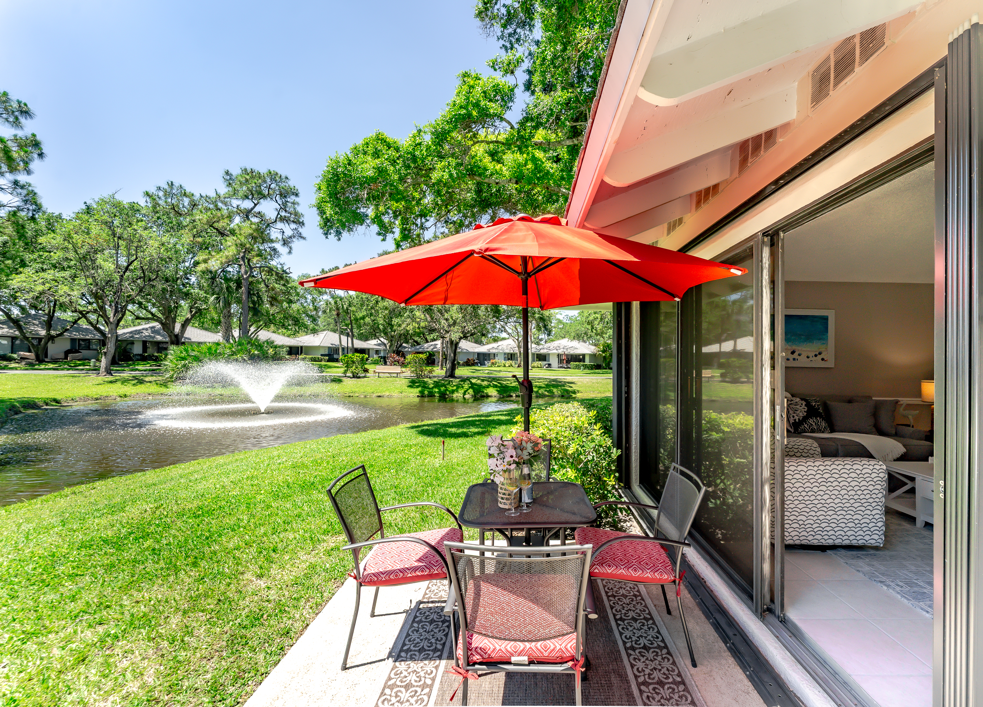 Private lakeside patio with outdoor dining, umbrella, and grill—perfect for morning coffee or sunset meals by the water

