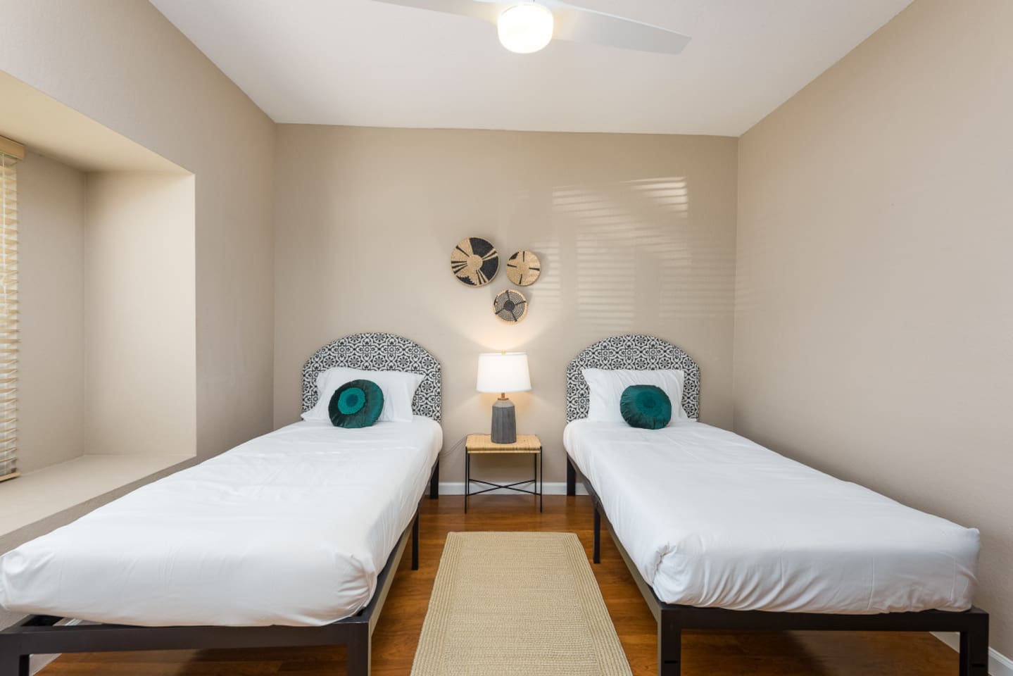 Guest Bedroom 3 with two twin beds, bedside table, ceiling fan, and a simple setup that works well for kids or extra guests.