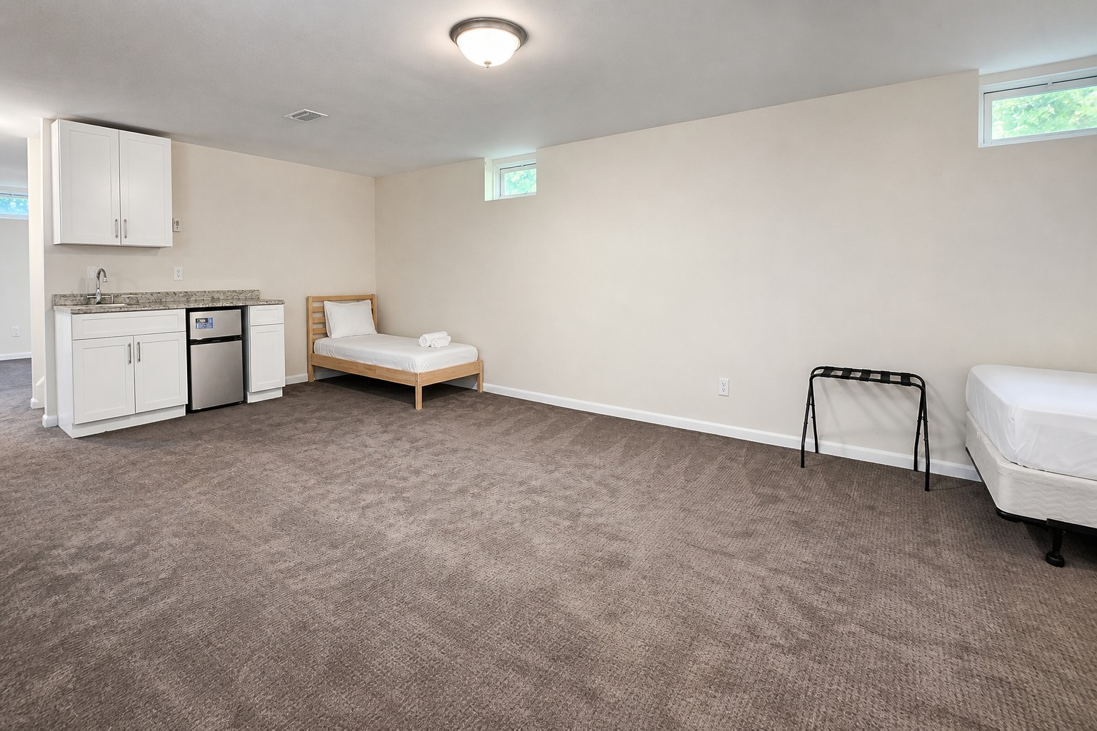 Lower-level kitchenette with a sink and mini fridge