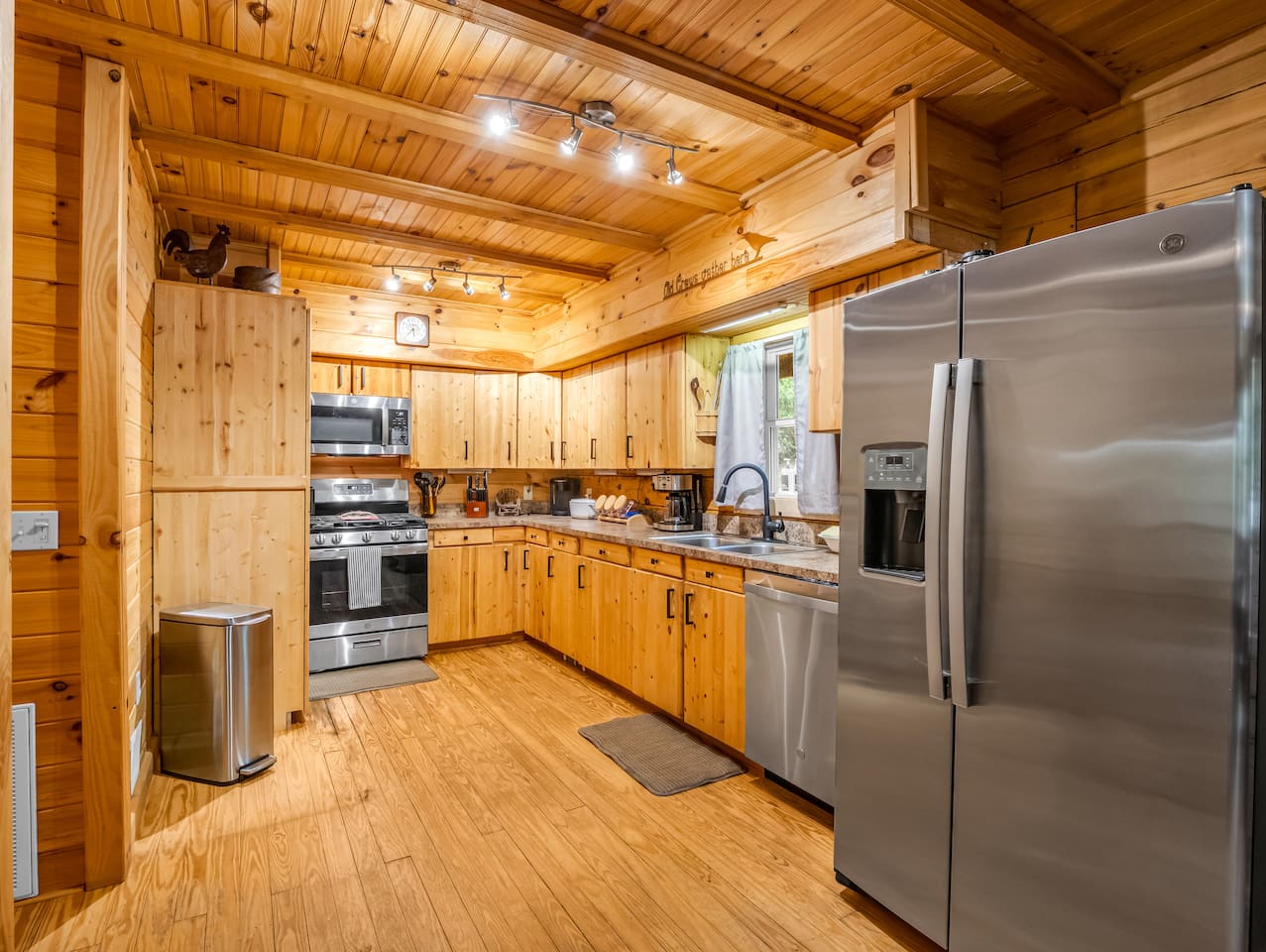 Fully equipped kitchen featuring stainless steel appliances, ample counter space, and rustic cabin charm 