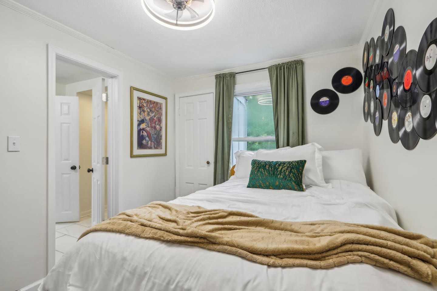 Recharge in Bedroom 2, featuring a comfortable king-size bed, soft layered bedding, and playful record-inspired décor.
