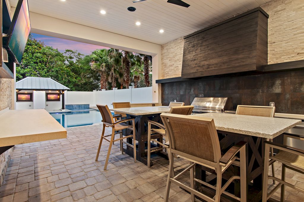 Grill, dine, and gather poolside in the outdoor summer kitchen