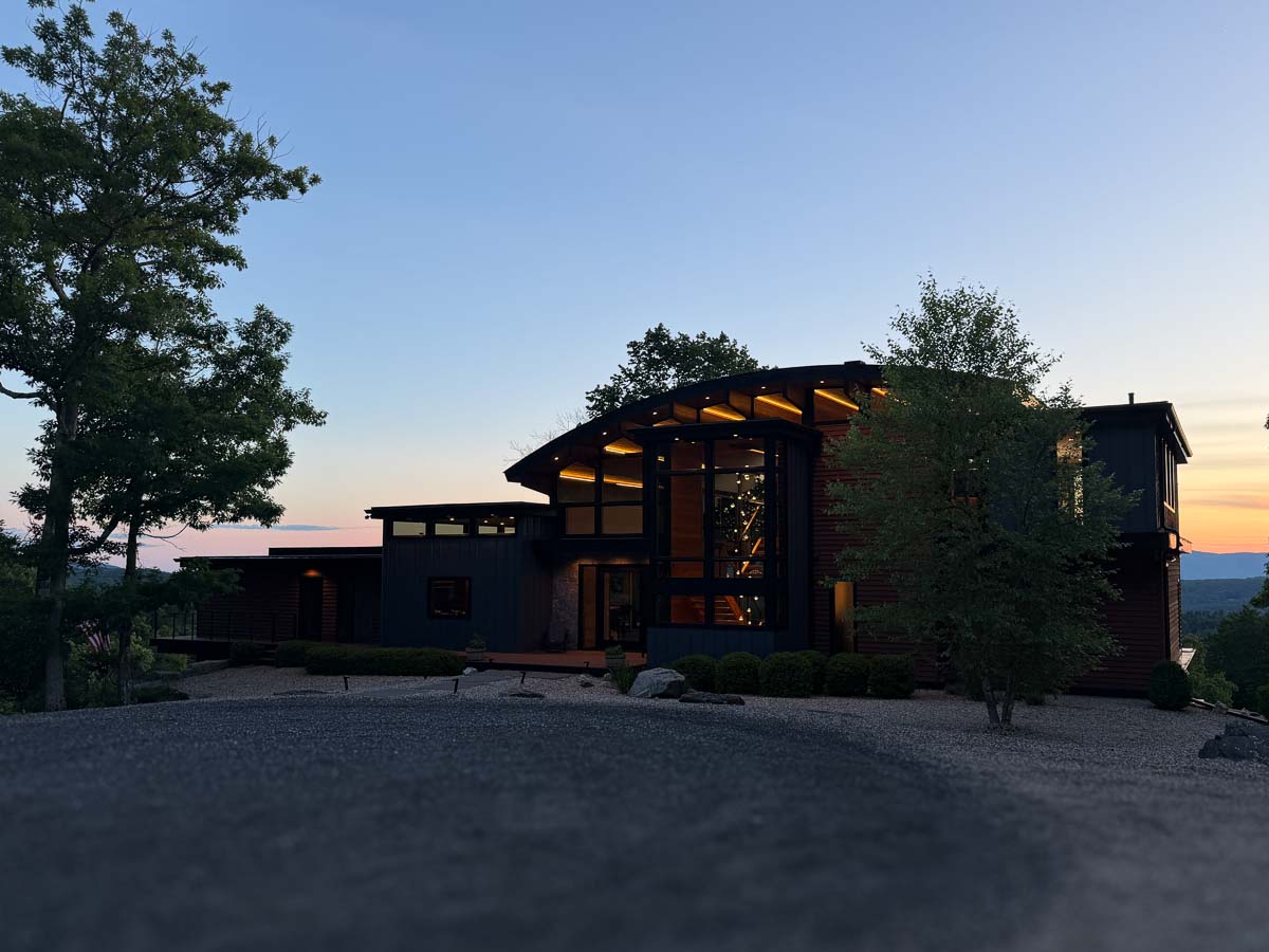 Sunset Falls Estate at dusk &mdash; the hanging pendant lights glowing through the glass &mdash; Berkshires