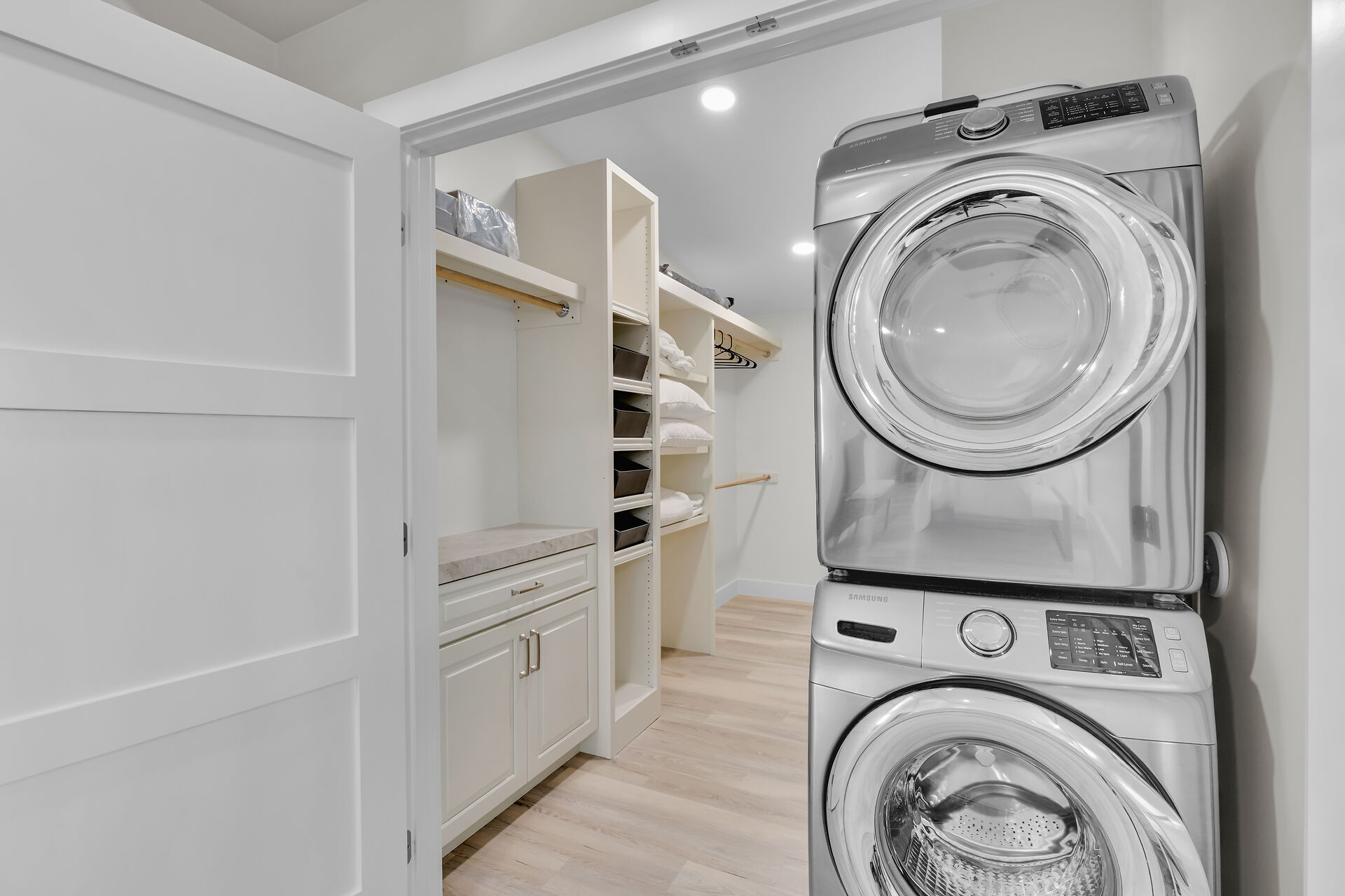 Laundry within large primary suite walk-in closet. 