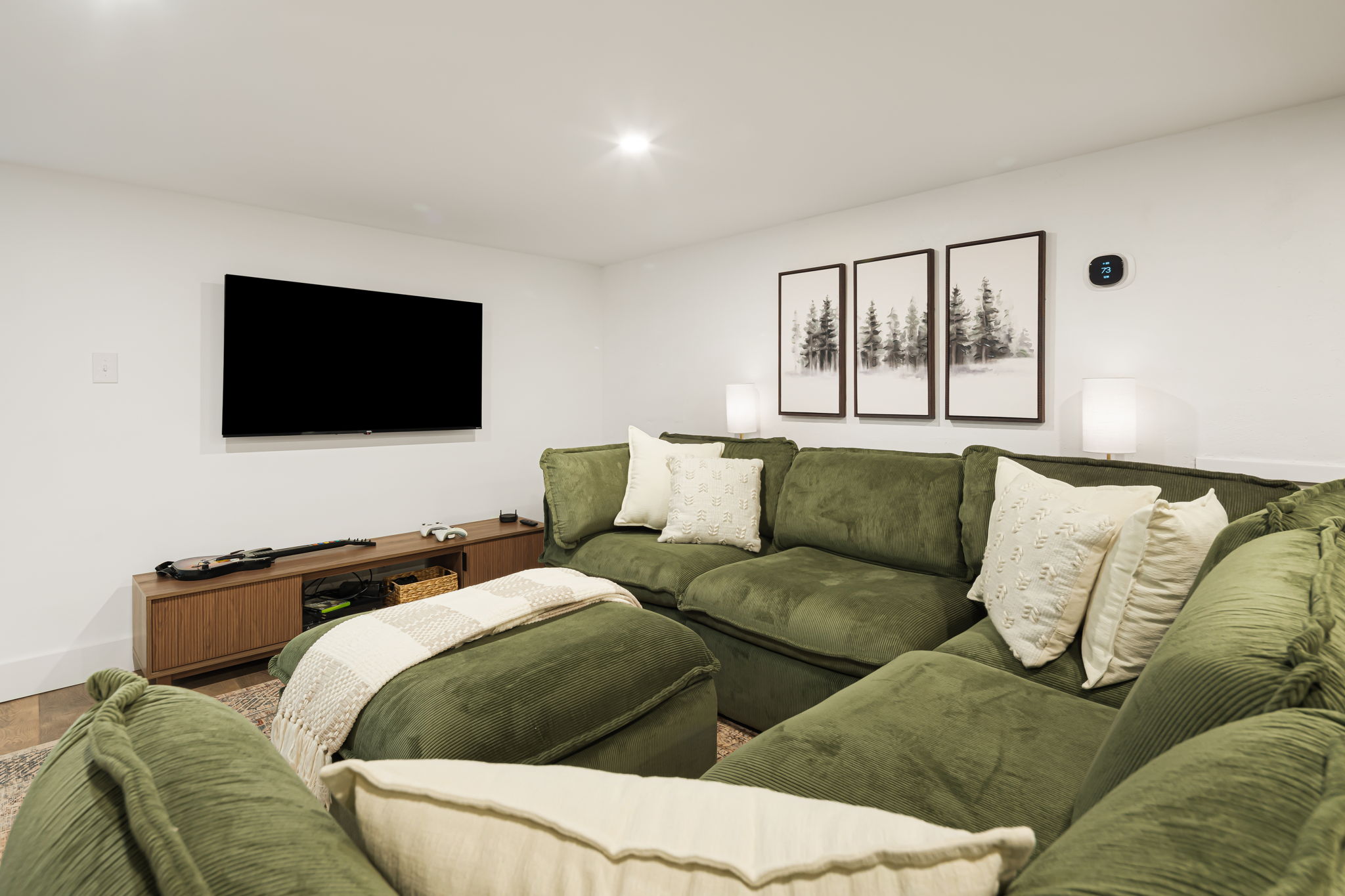 This area of the basement has a super comfortable sectional and ottoman. Perfect for movie watching or playing games.