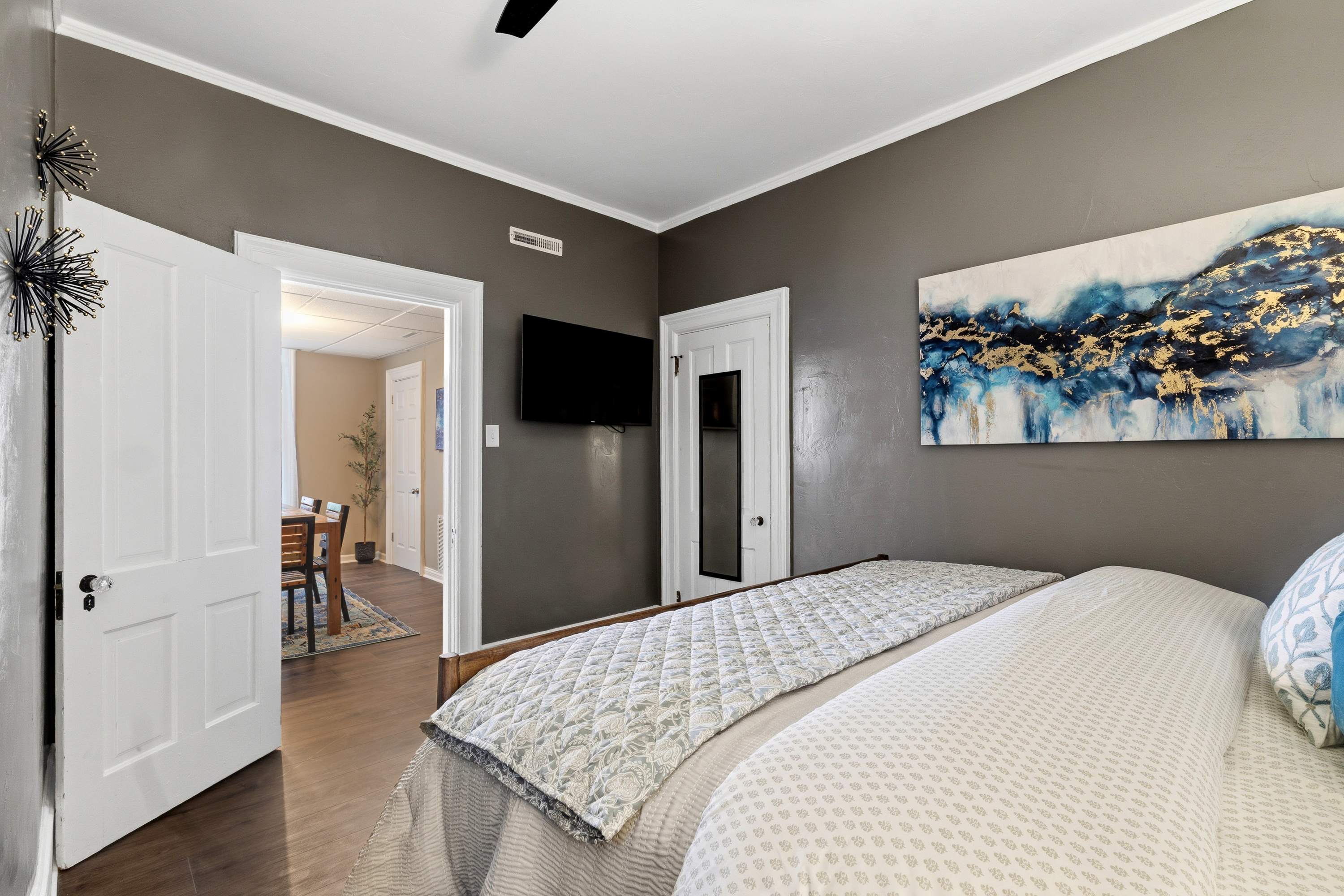 King bedroom includes a wall-mounted smart TV and opens directly to the dining area