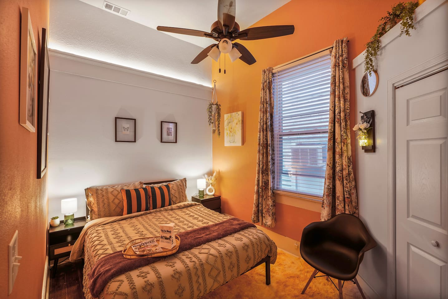 Hanging plants add a vertical touch to the tropical Pink Room with 12-foot ceilings, a queen bed, and a closet.

