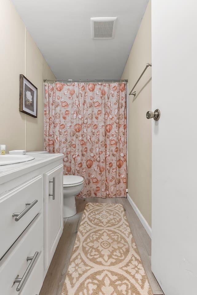 Clean vanity with marble-style countertop, mirror, and essential toiletries provided.