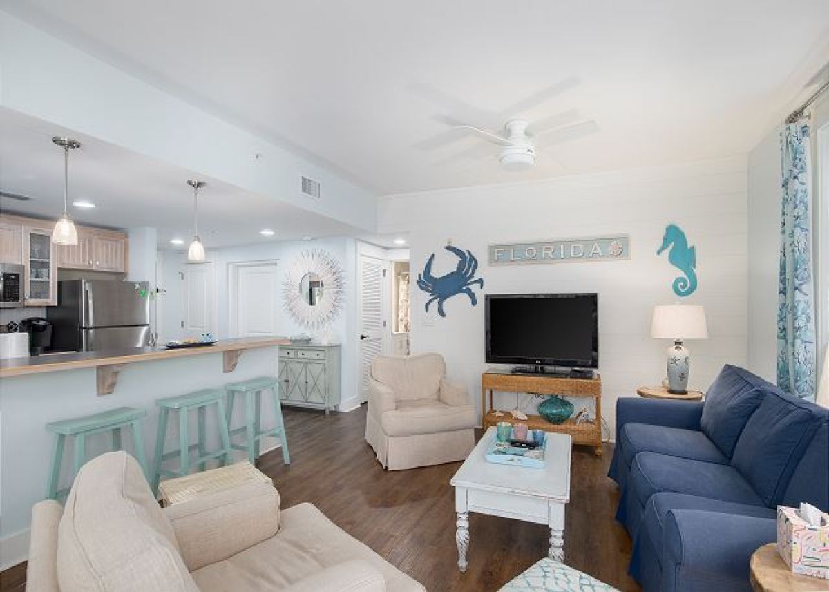 Living room with HDTV and sleeper sofa, looking toward the kitchen bar and entry