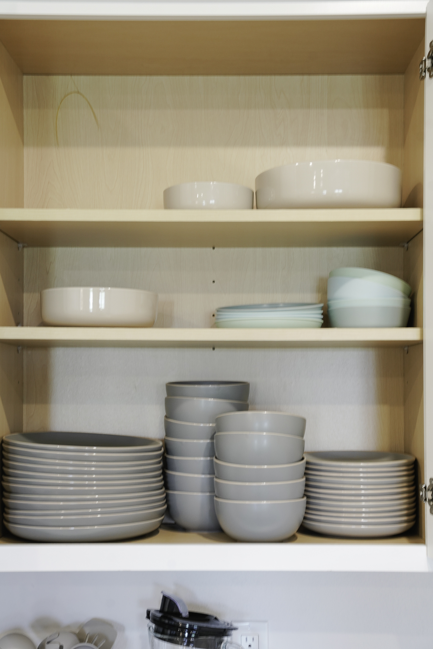Fully stocked kitchen with utensils, plates, bowls, cups, and glasses
