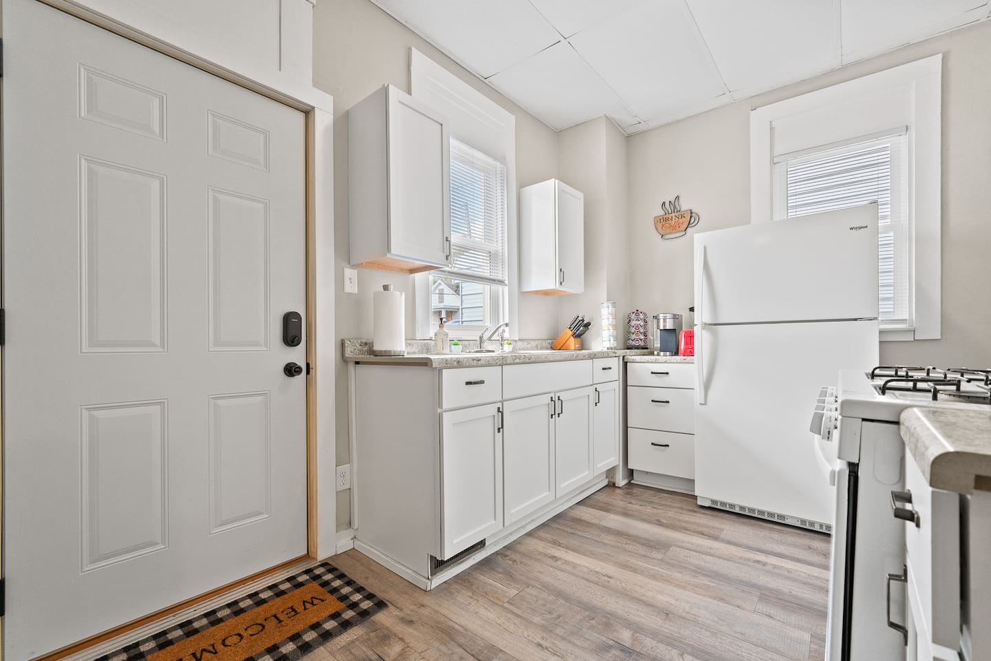 Practical and stylish kitchenette equipped with a stove, microwave, and refrigerator for your stay.