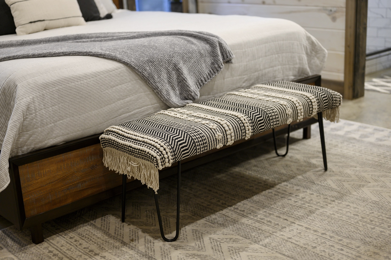 A bench at the foot of the bed, made for unhurried moments. Tie your boots for the trail or wrap up in a blanket for one more chapter.