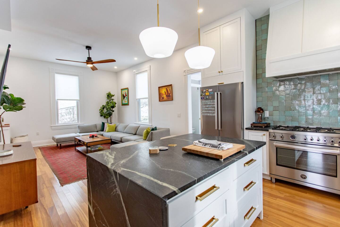 A spacious kitchen with a large center countertop that offers seating for two, creating a perfect spot for casual meals or conversation, all while providing a lovely view of the living area.