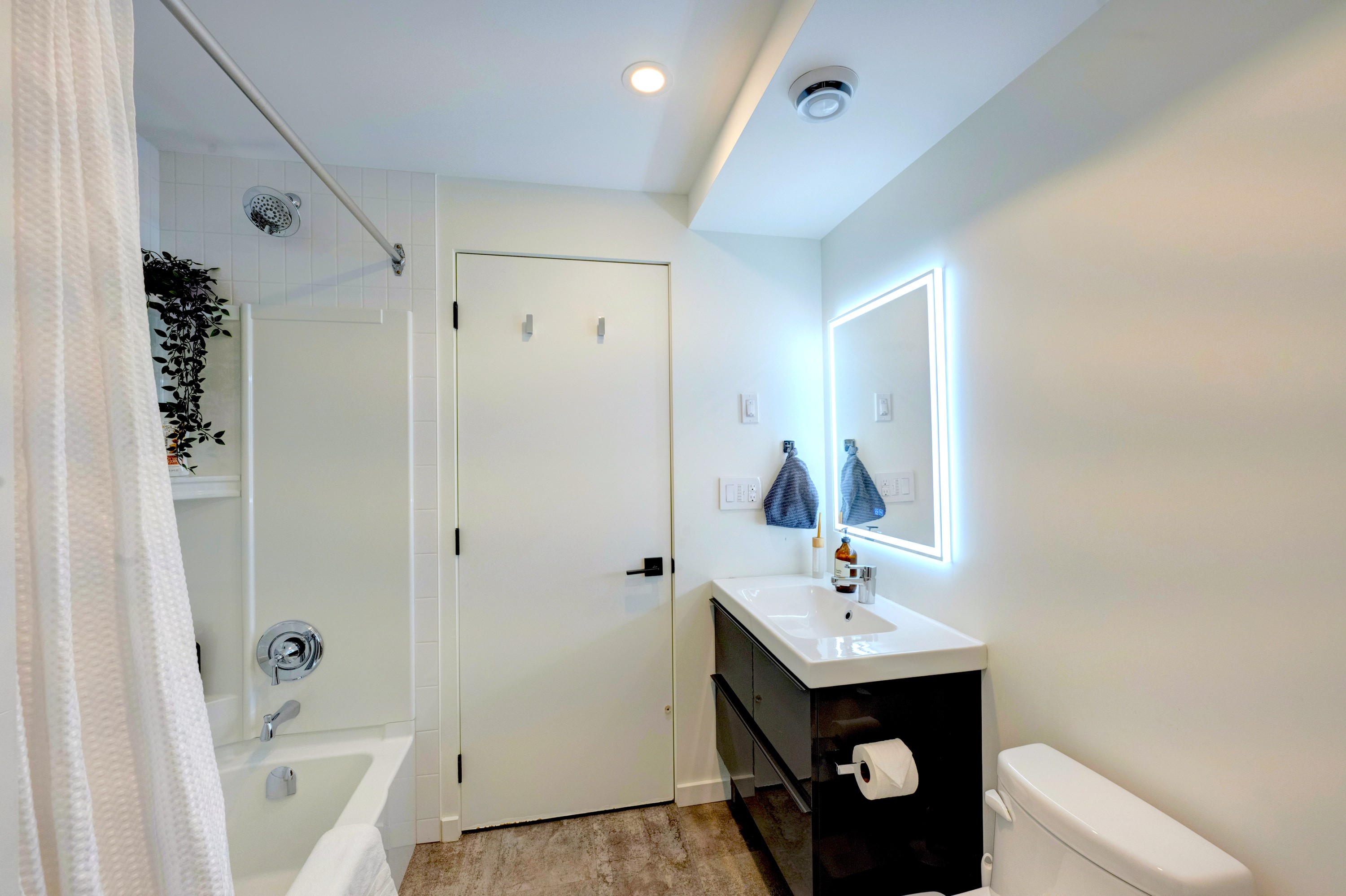 Full bathroom with tub/shower combo and thoughtful storage — simple, calm, and easy to use.