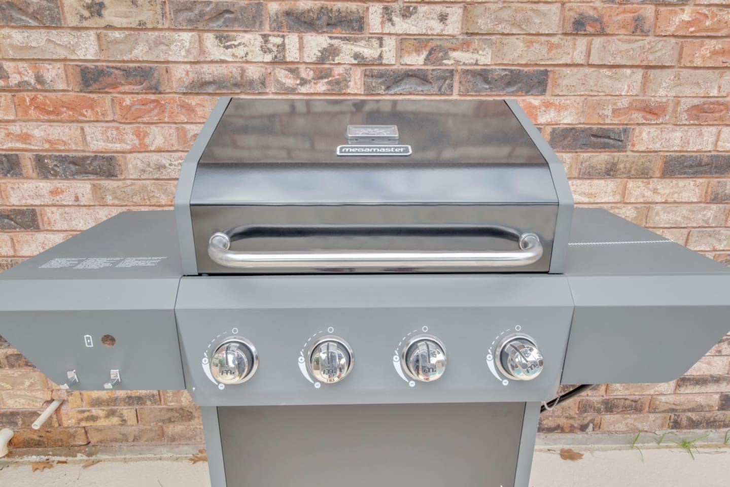 Modern gas BBQ gas grill with barbecue utensils, perfect for backyard cookouts and relaxed evenings by the outdoor dining area.