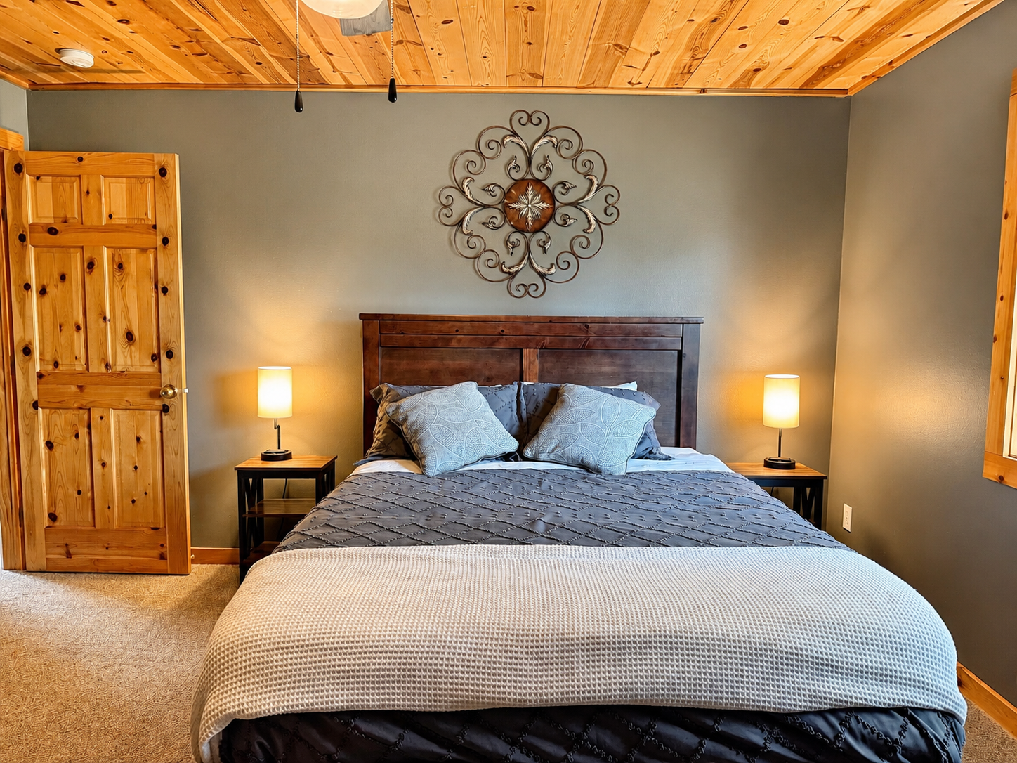A closer look at the bedroom shows a cozy sleeping setup with bedside lighting and plenty of room to settle in.
