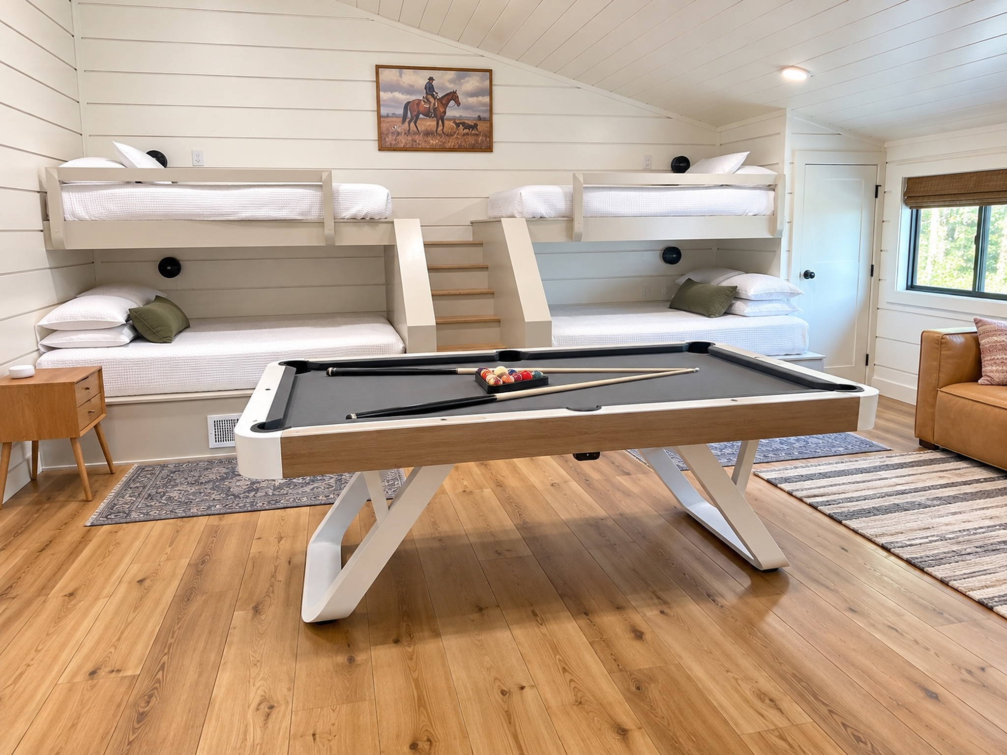 The ultimate bunk room for kids and adults alike - two queen and two twin beds, easy stair access to top bunks, and a modern leather couch for watching movies or just simply relaxing during your stay.