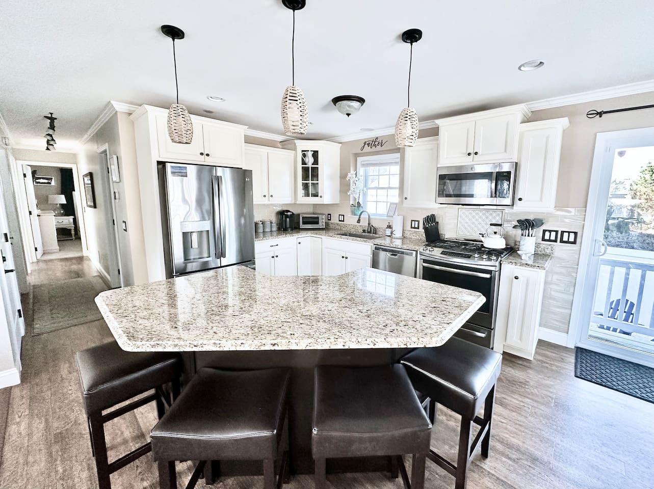 Gather around the spacious granite island, complete with seating for four. This fully equipped kitchen features stainless steel appliances and ample counter space, making it an ideal spot for morning coffee or casual group meals.