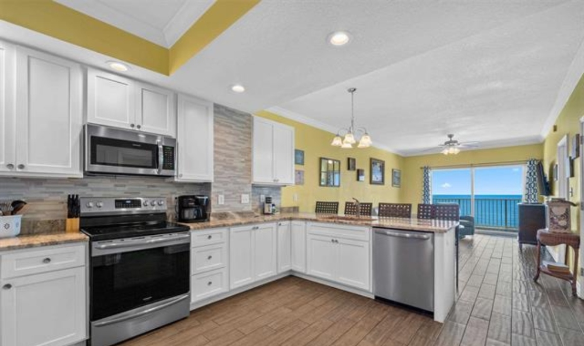 ENLARGED kitchen with stainless steel appliances (electric range, above range microwave, dishwasher, fridge with ice maker, solid wood cabinets, granite countertops and tiled backsplash