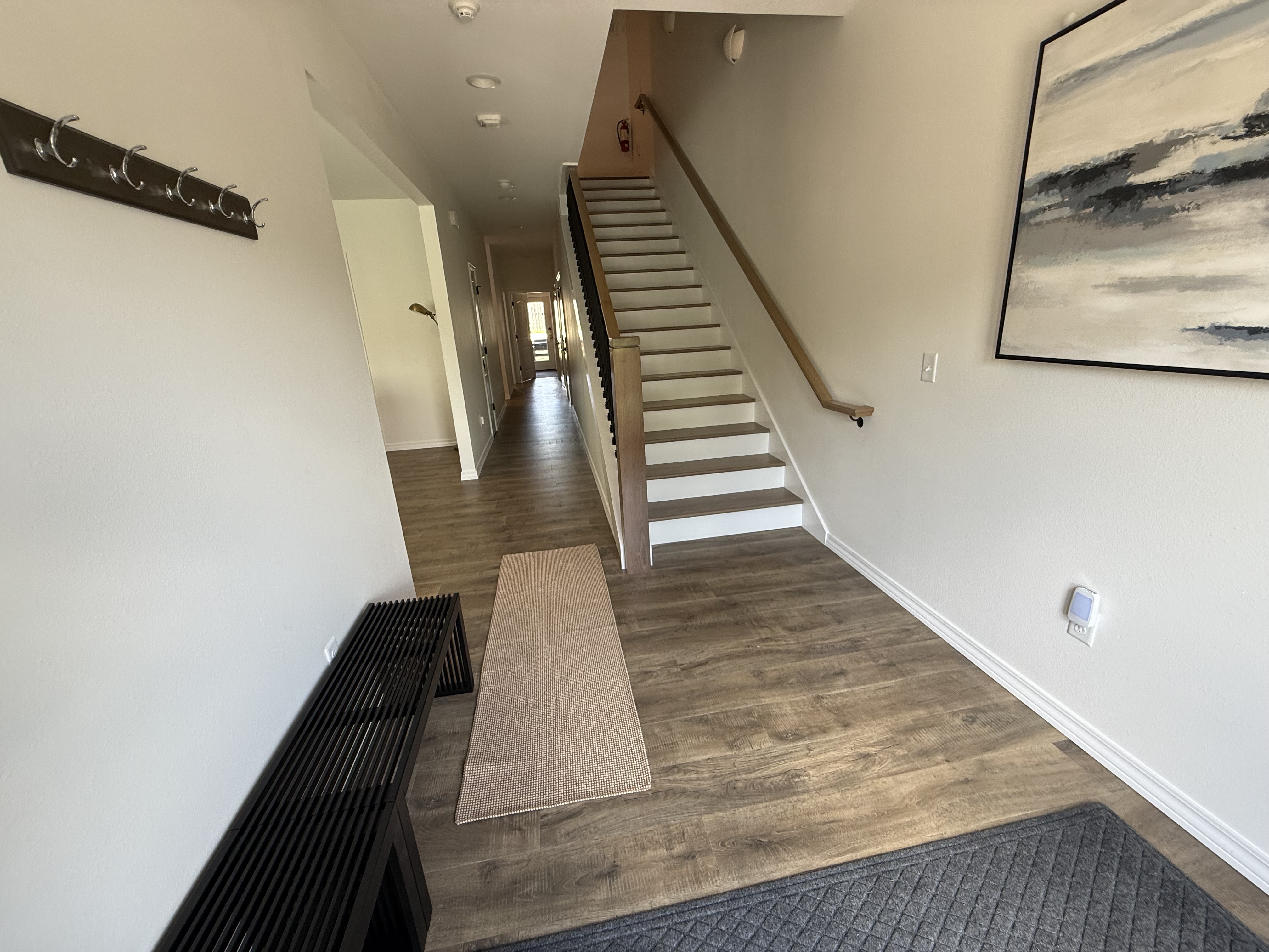 Hallway. Stairs to second floor. Hand stained steps and railings.